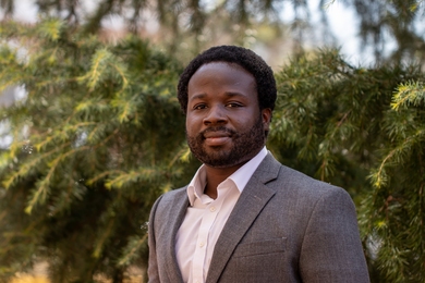 Portrait headshot of Robert Gilliard standing in front of pine trees