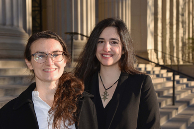 Photo of Elizabeth Yarina and Courtney Lesoon in front of the steps to MIT’s main entrance
