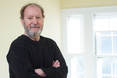 Portrait photo of Martin Greenwald, standing with his arms folded in front of a window