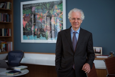 Photo of Richard K. Lester, wearing a suit and standing in a tidy office