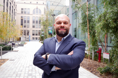 Photo of Jonathan Schwarz posing on the Improbability Walk between MIT.nano and Building 10