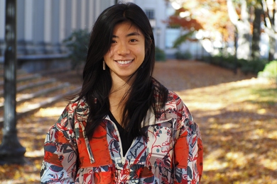 Portrait photo of Sarah Cen posing outdoors in a colorfully patterned jacket
