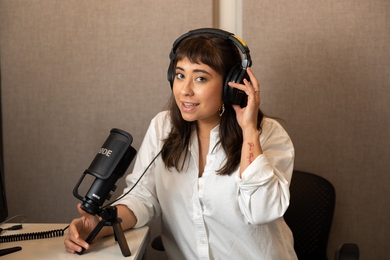 Photo of Jessica Chomik-Morales wearing headphones and seated in sound booth.