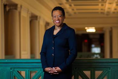 Photo of Melissa Nobles, and in background is the railing, columns and ceiling of Memorial Lobby.