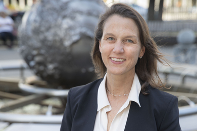 Khurana portrait photo while outside in Kendall Square, with “Galaxy: Earth Sphere” sculpture in background.