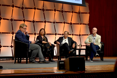 Four people seated together on a stage in discussion.