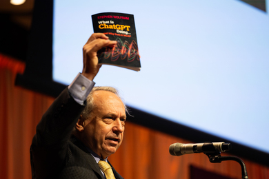 Rodney Brooks holding up a book while speaking