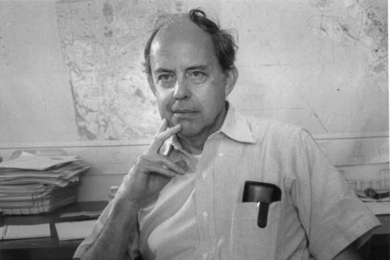 A black-and-white portrait of Fred Hennie in his office, likely dating from the 1980s.