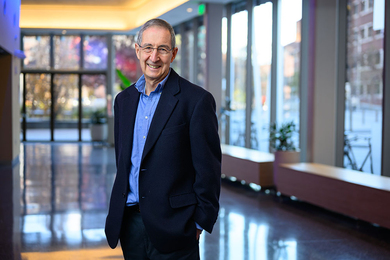 Portrait photo of Leon Sandler standing in the foyer of an MIT building