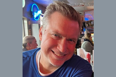 Photo of Casey Harrington smiling while at a restaurant.