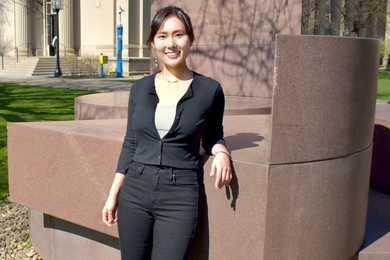 Jeong Min Park poses leaning on an outdoor sculpture in Killian Court.