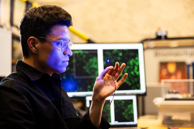 The blue glow of a tiny light shines on Guillermo Herrera-Arcos’s face inside the lab.