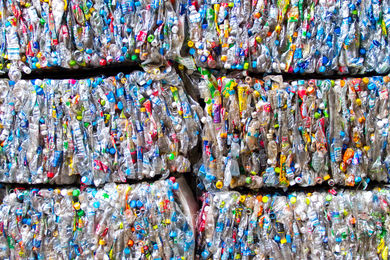 Plastic bottles crunched into stacked bricks.
