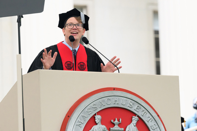 Hank Green speaks at podium, which has the MIT seal.