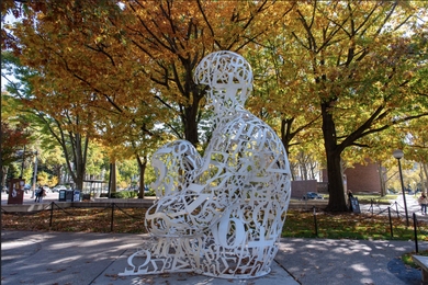 The Alchemist sculpture surrounded by autumn trees on MIT’s campus