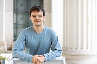 Portrait photo of Sergei Kotelnikov next to a large column of an MIT building