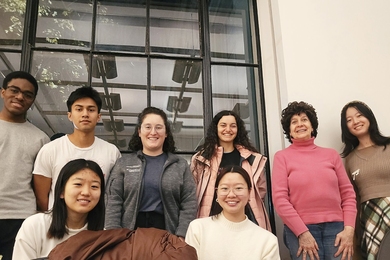 Group shot of 8 students outside a building