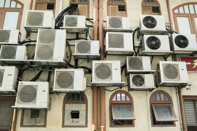 The outside of a building with numerous air conditioner compression units.