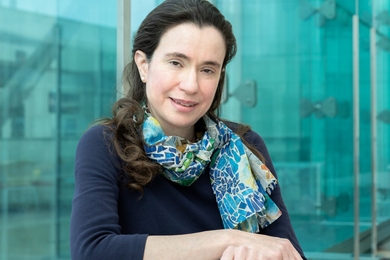 Myriam Heiman poses in front of an aqua glass wall
